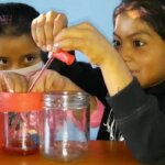 Dos niñas desarrollando un proyecto científico que simula el funcionamiento del corazón.